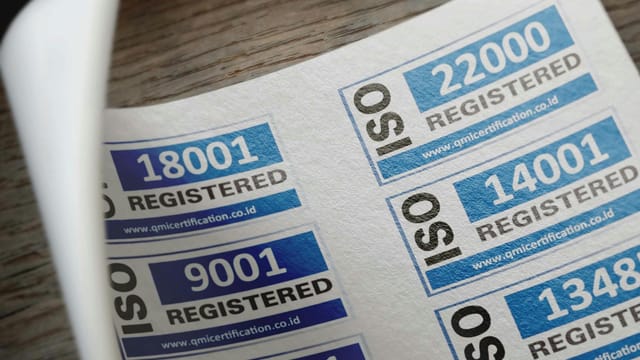 ISO certification stickers with registration numbers on paper.