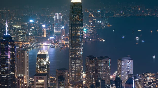 A breathtaking night view of Hong Kong Island's skyline featuring iconic skyscrapers and bustling city lights.