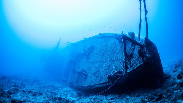 Discover the haunting beauty of a sunken shipwreck off Okinawa's coast.