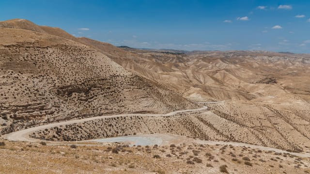 Rugged desert landscape in Israel, showcasing arid hills under a clear blue sky.