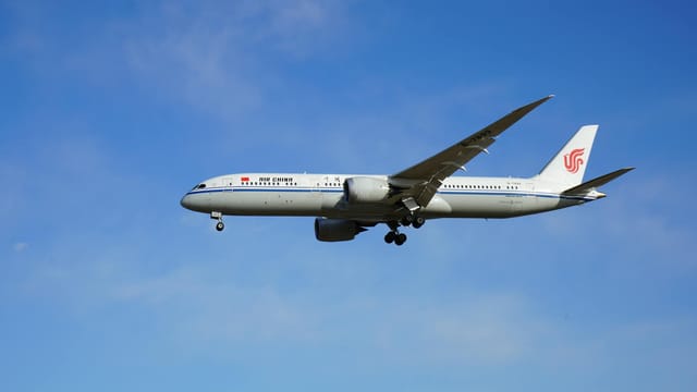Air China passenger jet soaring through a clear blue sky, showcasing modern air travel.
