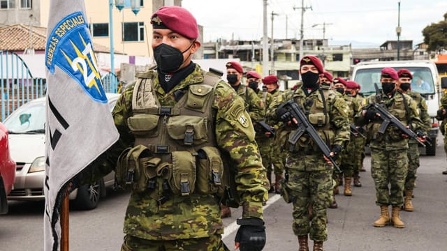 Ecuadorian soldiers in camouflage and berets participating in a parade, showcasing military discipline.