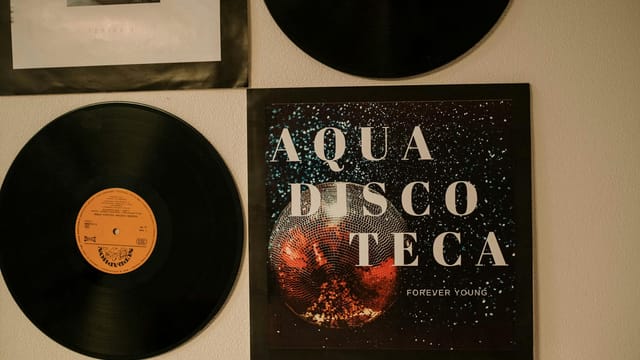 Collection of retro vinyl records on a wall with nostalgic music vibes.