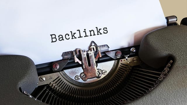 Close-up of a vintage typewriter printing the word 'Backlinks,' emphasizing content and SEO concepts.