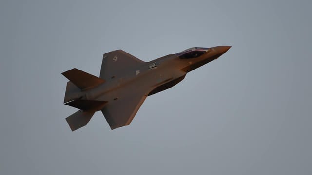 Impressive view of an F-35 fighter jet soaring through the sky at twilight.