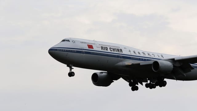 Air China aircraft approaching landing at Frankfurt Airport on a cloudy day.