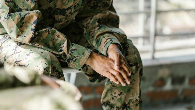 Detail view of a soldier's hands and uniform showing focus and honor.