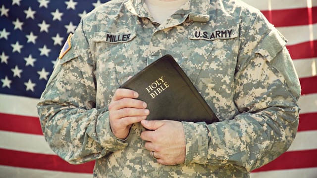 American soldier in uniform holding the Holy Bible, symbolizing faith and patriotism.