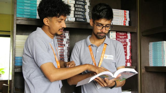 Two South Asian students engaged in a study session at a university library, Nepal.