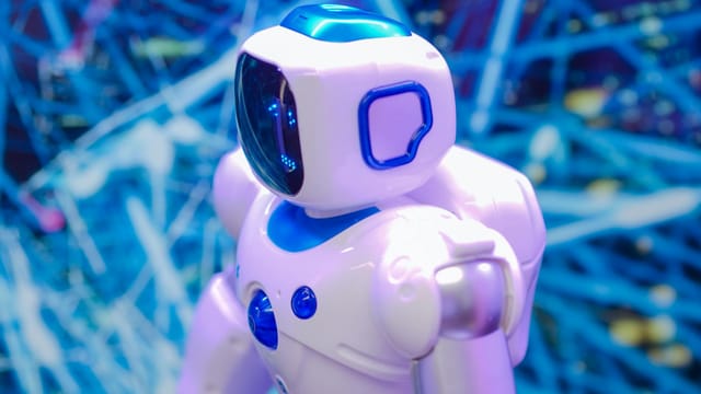 Close-up of a white and blue robot against a dynamic, futuristic tech backdrop.