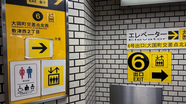 Detailed view of exit signs in Daikokucho Station, Osaka subway.