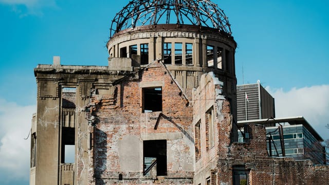 Historic Hiroshima Peace Memorial, a UNESCO site, under a clear blue sky.