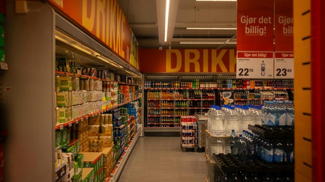 Colorful drink aisle in a supermarket with signage promoting deals.