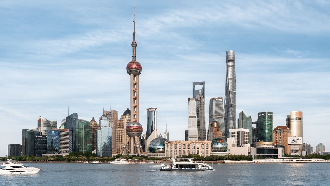 View of Shanghai skyline with the iconic Oriental Pearl Tower and modern skyscrapers from the river.