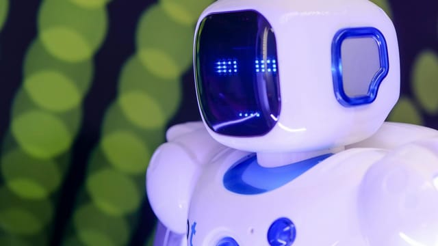 Close-up of a modern humanoid robot with glowing blue features on a green abstract background.