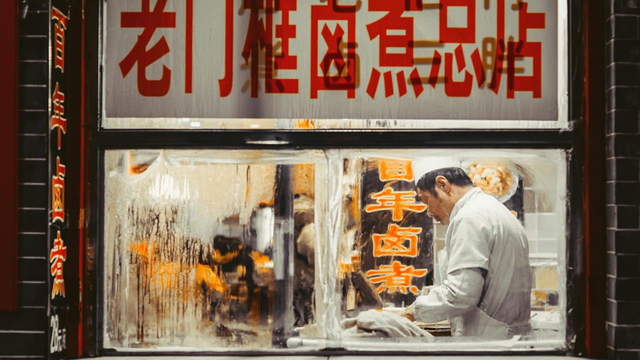 Chef working in a traditional Beijing restaurant kitchen, showcasing authentic Chinese cuisine.
