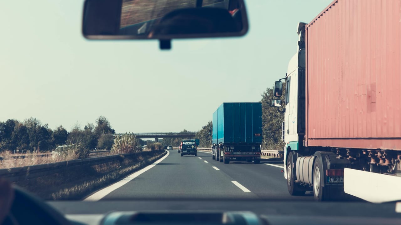 View through rearview mirror of trucks on a German highway, driving towards Bamberg.