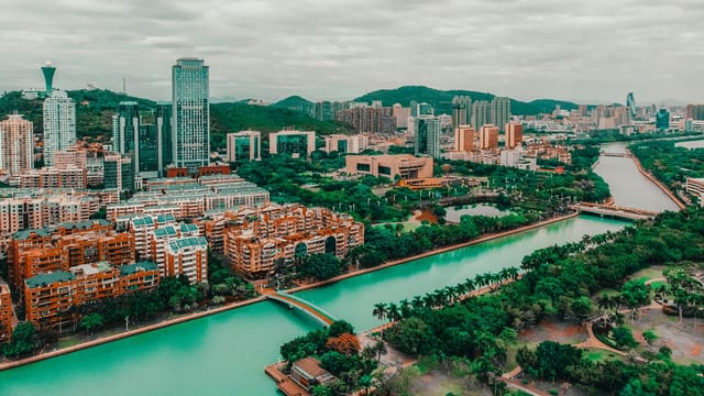 Stunning aerial view of Xiamen city skyline and river, capturing modern buildings and lush greenery.