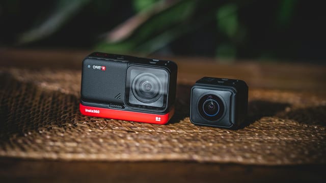 Two modular action cameras resting on a wooden table, ideal for tech enthusiasts and content creators.