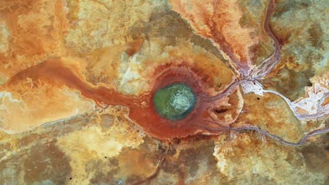 A stunning aerial perspective of the colorful Dallol volcanic landscape in Qinghai, China, showcasing vivid mineral formations.