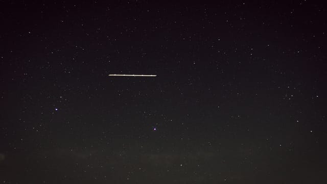 Captivating star-filled night sky with a mysterious line of light, captured in Germany.