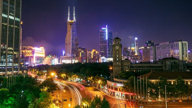 A mesmerizing cityscape at night featuring illuminated skyscrapers and busy street light trails.