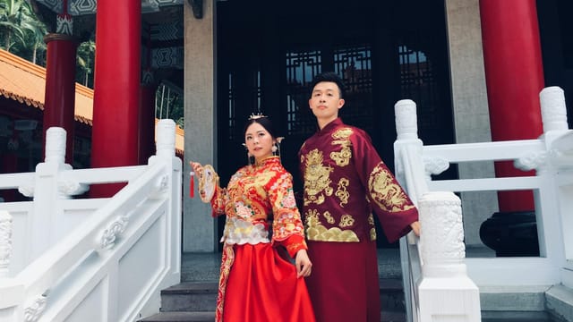Elegant couple in traditional Chinese wedding costumes at a temple in Ji Lin Sheng, China.
