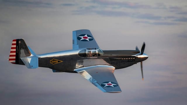 A historic fighter aircraft flying through the sky at sunset, showcasing classic aviation design.