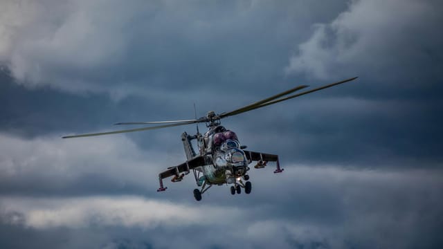 A Mi-24 military helicopter flying through overcast skies in Slovakia.