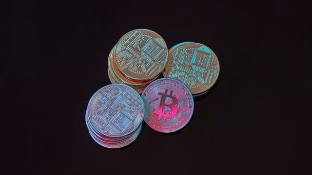 A detailed image showcasing a stack of Bitcoin cryptocurrency coins on a black background.