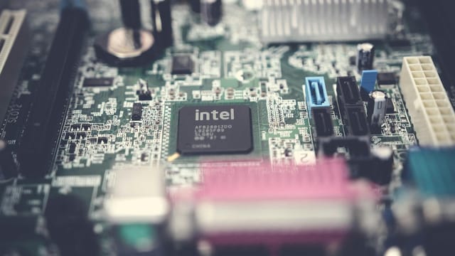 Detailed image of a computer motherboard highlighting an Intel chip with surrounding components.