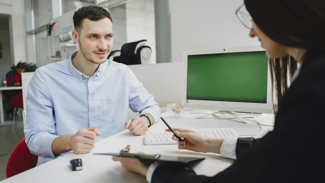 A business meeting between two office professionals, discussing strategies in a modern office.