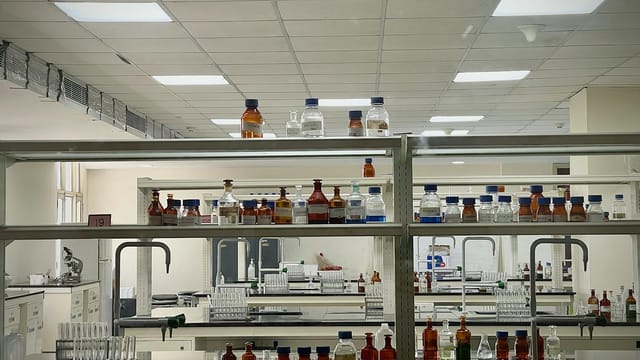 A detailed view of a modern science lab with chemical bottles and test tubes.