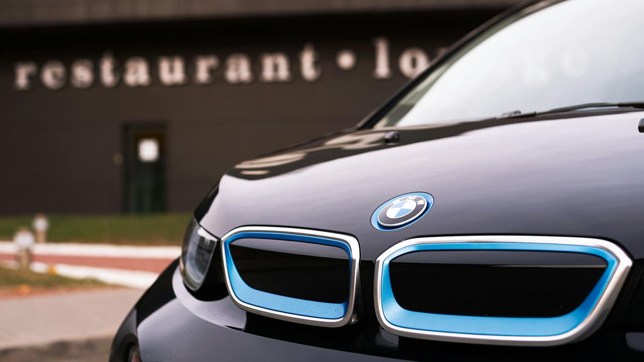 Detailed close-up of a BMW car emblem outside a restaurant.
