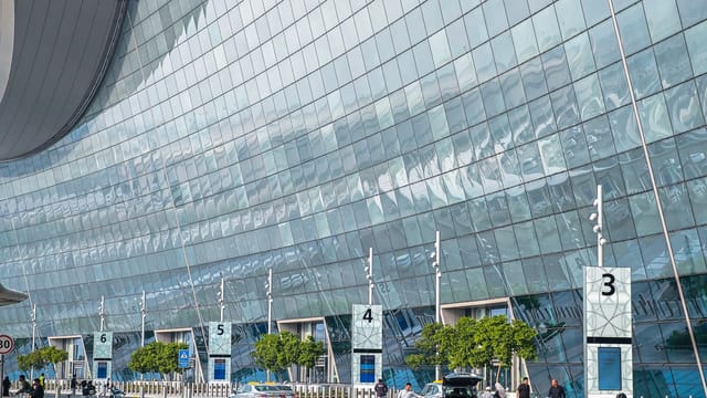Stunning modern facade of an airport terminal in Abu Dhabi with reflective glass and contemporary design.