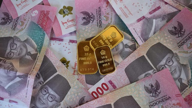 Close-up of Indonesian Rupiah banknotes with fine gold bars, symbolizing wealth and investment.