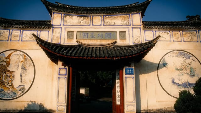 Ancient Chinese temple entrance adorned with dragon and tiger murals.