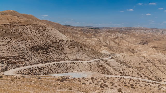 Rugged desert landscape in Israel, showcasing arid hills under a clear blue sky.