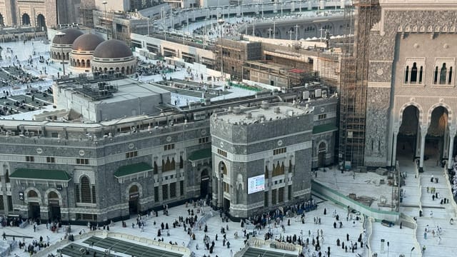 A stunning aerial view of the Masjid al-Haram, capturing the bustling courtyard in Mecca, Saudi Arabia.