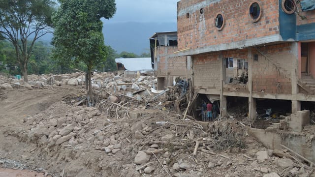 Destruction from landslide in Mocoa, Colombia, showing damaged buildings and debris.