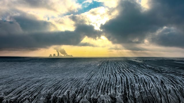 A dramatic aerial view of a power plant under cloudy skies in Boxberg, Germany.