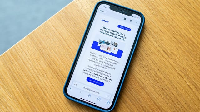 Smartphone displaying e-commerce advertisement on wooden surface, ideal for digital marketing themes.