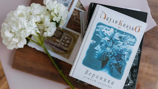 Flat lay of books with white hydrangea blooms, creating a serene and artistic composition.