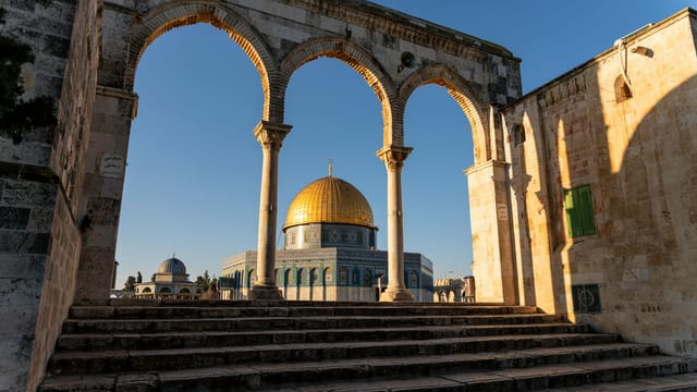 Beautiful view of the Dome of the Rock framed by arches in the Old City of Jerusalem.