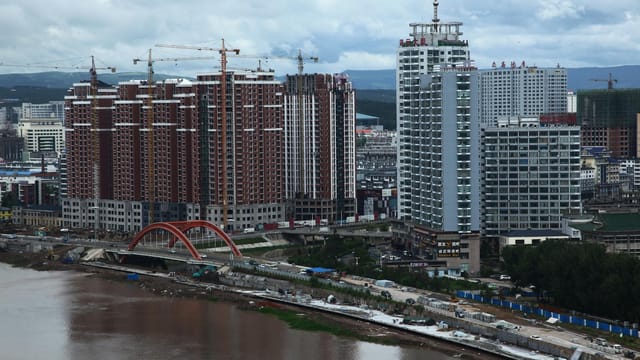 Aerial view of construction and urban growth in Yanji, China, featuring rising buildings.