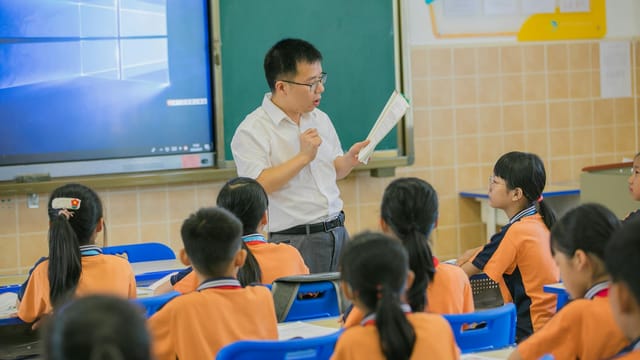 Teacher instructing attentive students in a classroom setting, fostering education and learning.