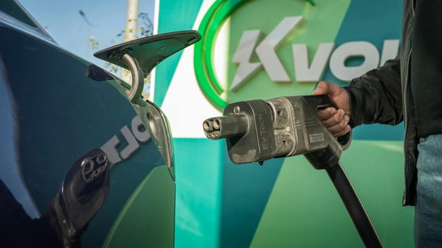 Close-up of an electric car being charged at a public station.