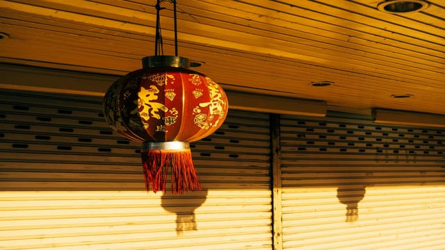A traditional red Chinese lantern casts a warm glow, symbolizing celebration and culture.