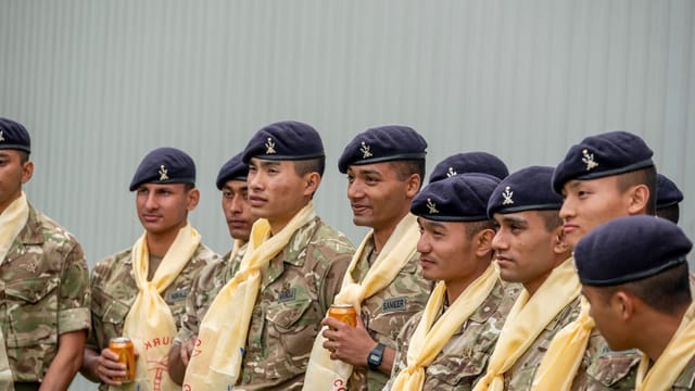 Group of Gurkha soldiers in uniform smiling during a ceremony in Catterick, England.