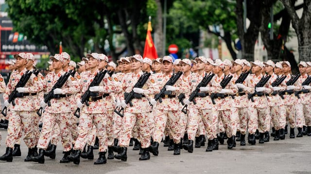Vietnamese soldiers march in a disciplined parade in Hanoi, displaying unity and strength.